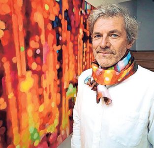 Kunstenaar Carl Soete bij zijn werk ‘Enthousiasme’. De foulard die hij draagt, kan je nu ook kopen.